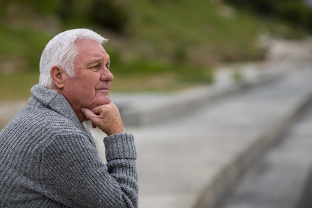 Senior man sitting on the steps near beachの写真素材