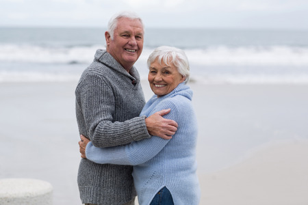 Portrait of senior couple standing together on the beachの写真素材