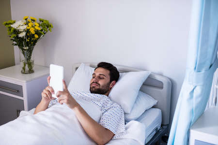 Male patient using digital tablet in the ward at hospitalの写真素材