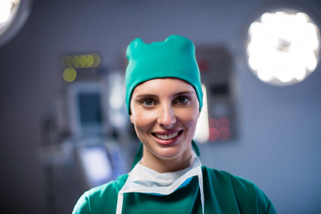 Portrait of female surgeon smiling in a operating room at hospitalの写真素材