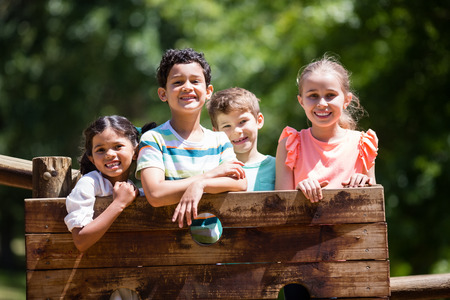 Kids standing on a playground ride in park on a sunny dayの写真素材