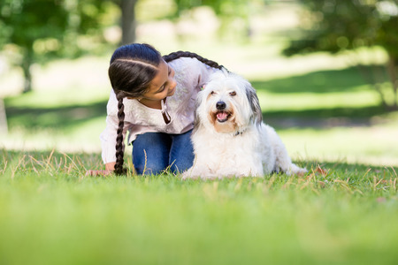 Girl playing with her pet dog in parkの写真素材