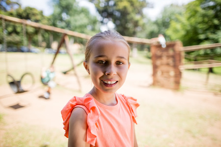 Portrait of innocent girl smiling in park on a sunny day