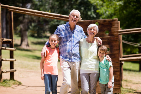 Grandparents enjoying time together with their grandchildrens in the park on a sunny day