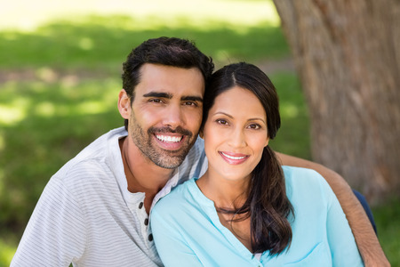 Portrait of smiling couple sitting together in a parkの写真素材