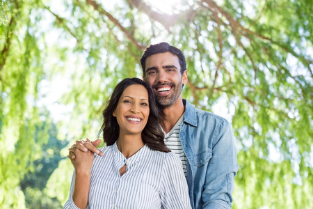 Portrait of romantic couple smiling in parkの写真素材