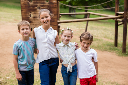 Portrait of happy kids standing together in park