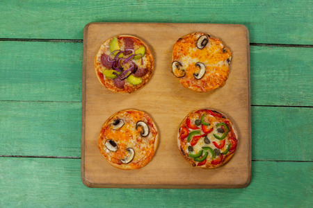 Overhead of various delicious italian pizza served on pizza trayの写真素材