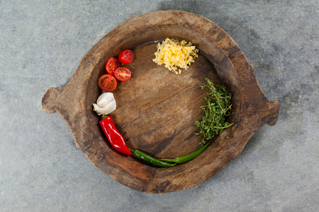 Overhead of spices and vegetable in wooden bowlの写真素材