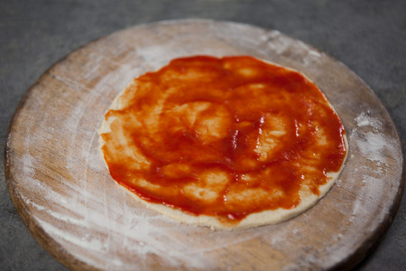 Close-up of pizza dough with tomato sauceの写真素材