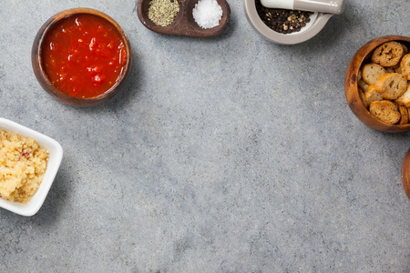 Ingredients, tomato sauce and toast in bowl on grey background