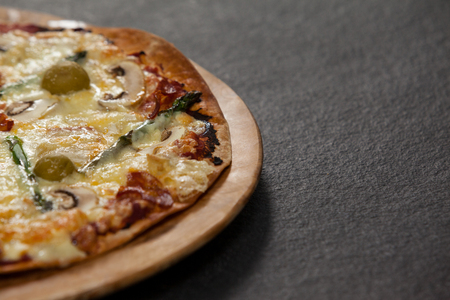Close-up of delicious italian pizza served on wooden boardの写真素材