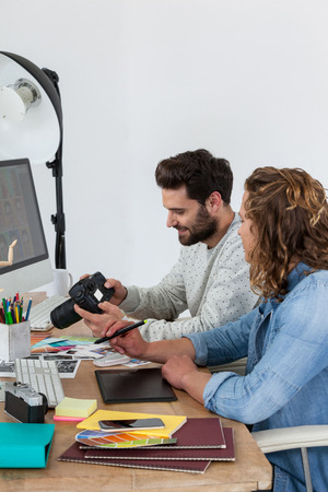 Photographers working together at the desk in officeの写真素材