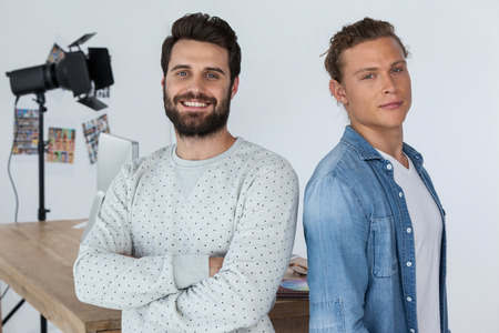 Portrait of smiling photographers standing in studioの写真素材