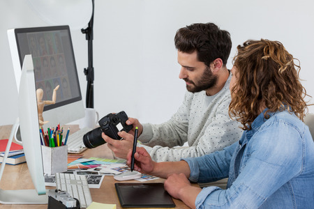 Photographers working together at the desk in officeの写真素材