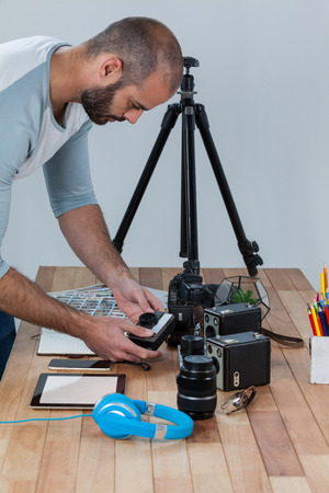Male photographer working at desk in studioの写真素材