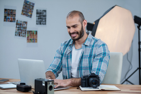 Photographer working over laptop in studioの写真素材