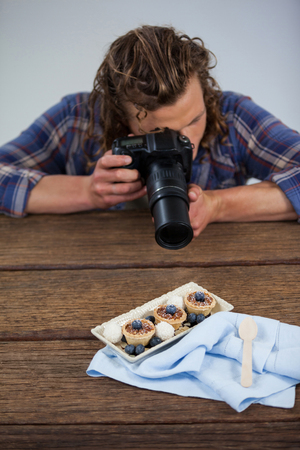 Male photographer photographing food in studioの写真素材
