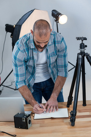 Male photographer working at desk in studioの写真素材