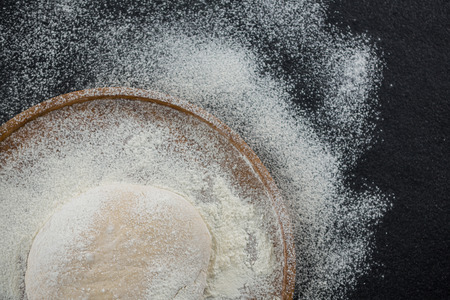 Overhead view of pizza dough ball on a wooden trayの写真素材