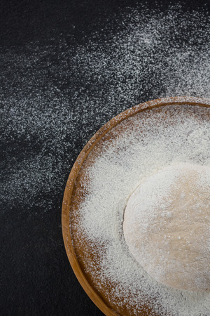 Overhead view of pizza dough ball on a wooden trayの写真素材