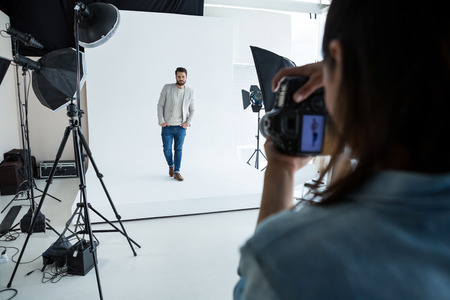 Male model posing for photographer in studio