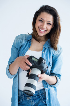 Portrait of happy female photographer standing in studioの写真素材