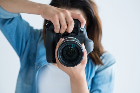 Female photographer with digital camera in studioの写真素材