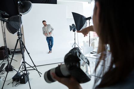 Male model posing for photographer in studioの写真素材