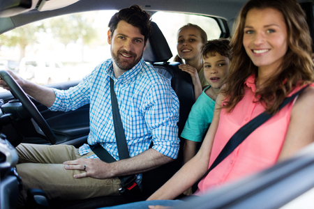 Portrait of happy family sitting in car