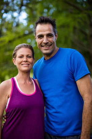 Portrait of couple with arms around in parkの写真素材