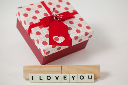 Conceptual image of gift and blocks displaying I love you messageの写真素材