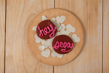 Cookies iced with pink cream displaying hey sexy on wooden surfaceの写真素材