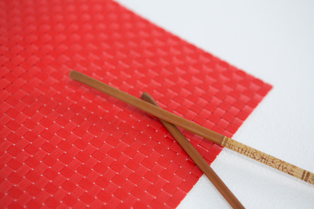 Close-up of sushi mat with chopsticks on white backgroundの写真素材