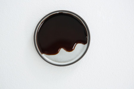Close-up of chocolate syrup on plate against white backgroundの写真素材