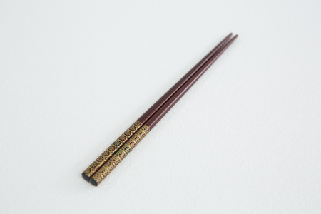 Close-up of brown chopsticks on white backgroundの写真素材