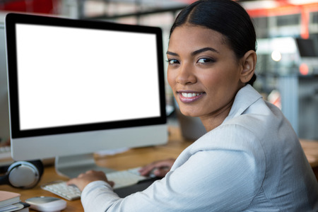 Portrait of businesswoman working over computer in officeの写真素材