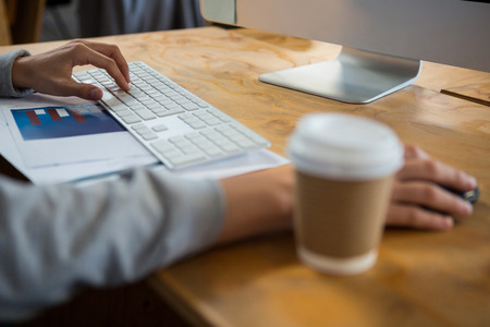 Close-up of businessman working at desk in officeの写真素材