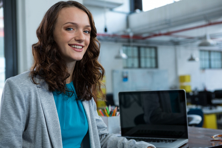 Portrait of businesswoman smiling at camera in officeの写真素材