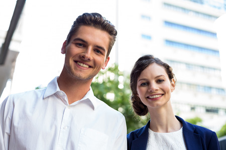 Portrait of businessman and woman smiling outdoorsの写真素材
