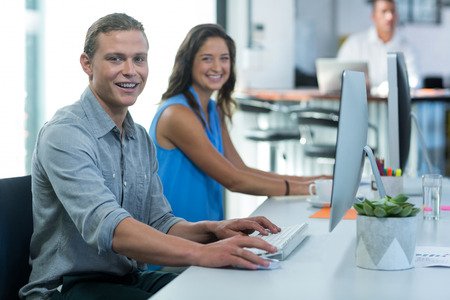Portrait of graphic designers working on personal computer in office