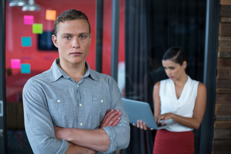 Portrait of confident business executive standing with arms crossed in officeの写真素材