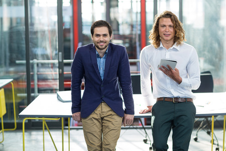 Portrait of smiling business executives standing in officeの写真素材