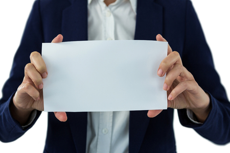 Mid section of businesswoman holding blank a paper against white backgroundの写真素材