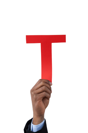 Close-up of businessman holding alphabet t against white backgroundの写真素材