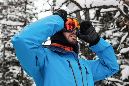 Skier adjusting his sunglasses while getting ready for skiingの写真素材