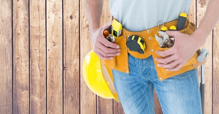 Digital composite of Carpenter against wood panelの写真素材