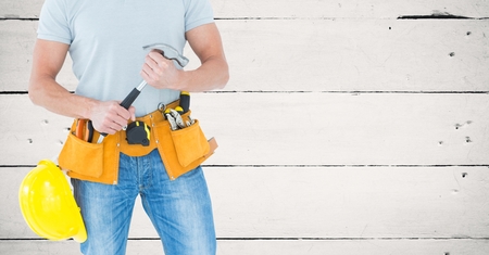 Digital composite of Carpenter with hammer against white wood panelの写真素材