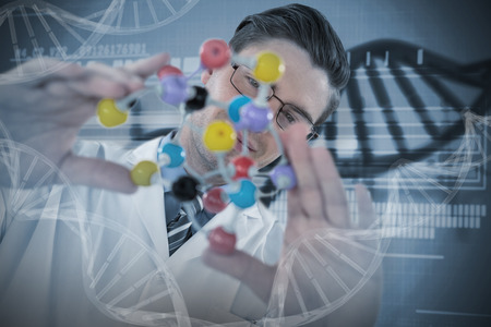 Scientist holding colorful molecule structure against genetic research information on dnaの写真素材
