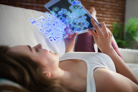 Brainstorm graphic against pretty woman lying on the couch while using tabletの写真素材